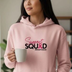 Woman in pink hoodie holding a mug.