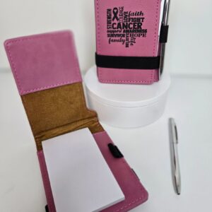 Pink notepad holder with cancer awareness text.