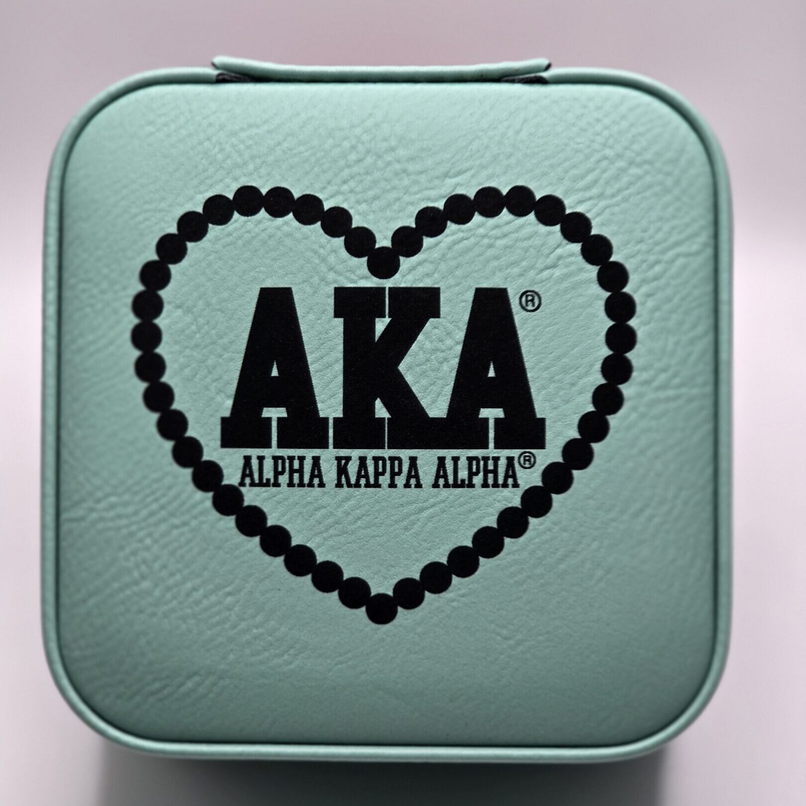 Mint green case with AKA heart logo